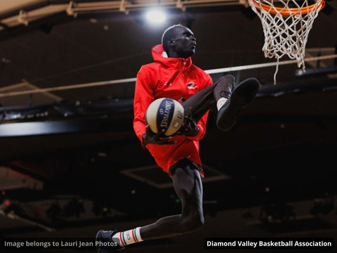 Man in a red Glide Tech zip hoodie making a basketball layup.